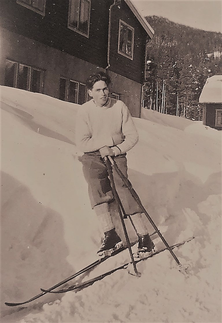 Bjarne Glimsdal i hvit strikkegenser. Dette var den eneste genseren som Bjarne eide. I den tiden krevde det egeninnsats for å skaffe seg en slik genser. Han reiste med buss, tog og til beins opp til Gudbrandsdalen som var et sauerikt dalføre med mye ull. Han fylte ryggsekken med nok ull for en genser! Bestemora kardet og spinnet ulla ferdig, og en ukjent jente strikka genseren for Bjarne. Vi er selvfølgelig interessert i hvem denne jenta er! 